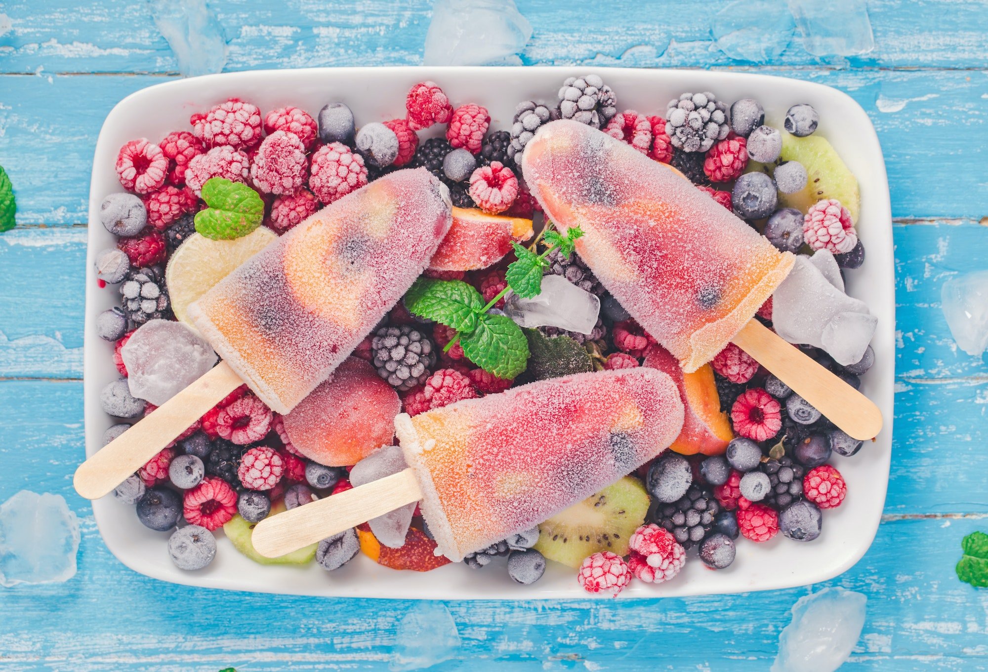 Ice pops on plate with frozen berries above
